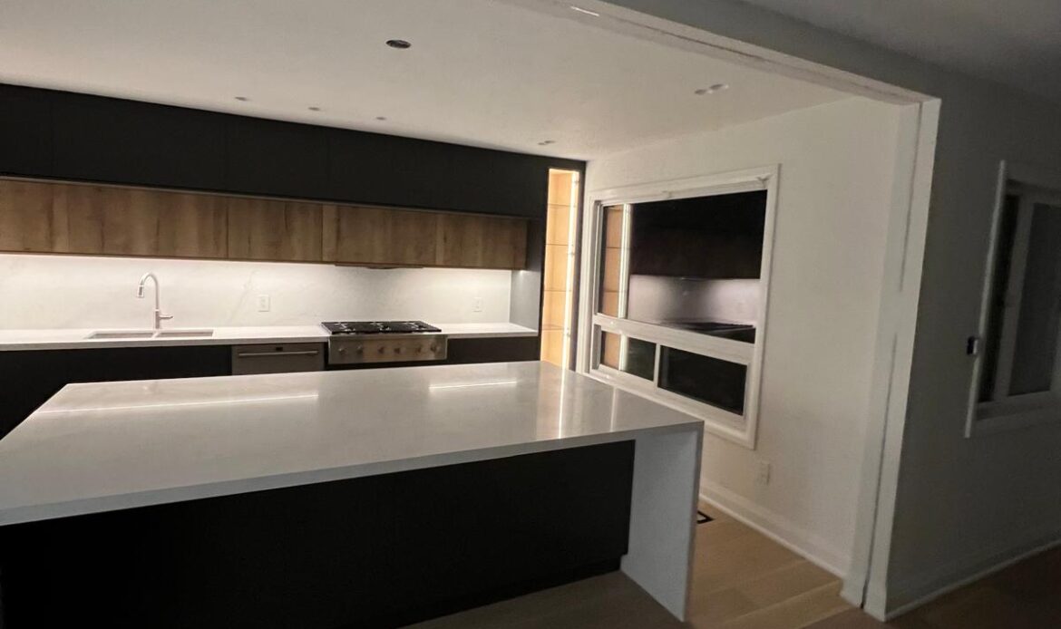 Modern black kitchen renovation with a large white island in the GTA