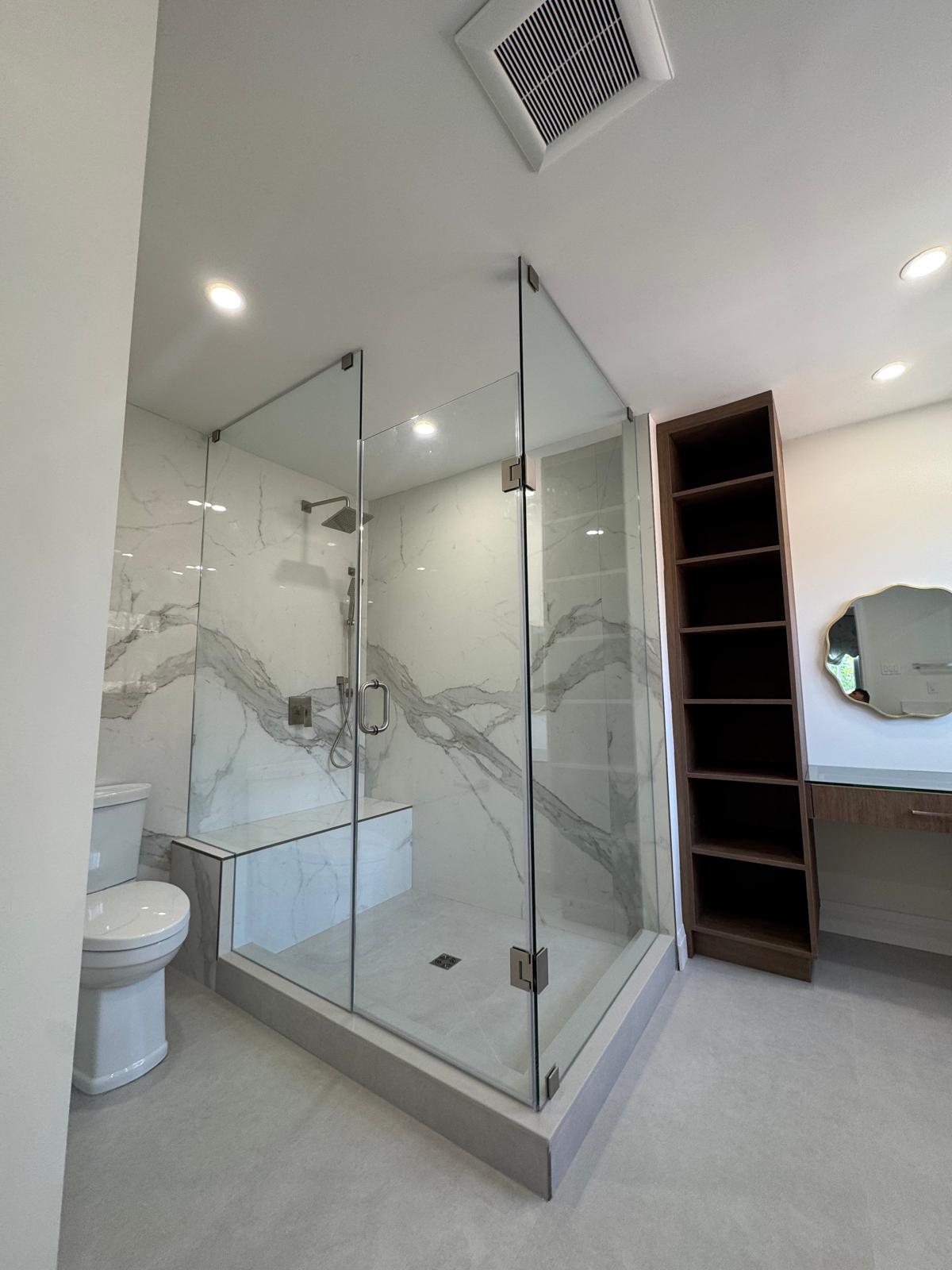 Renovated shower in Richmond Hill with a glass enclosure, pale veined walls and a bench